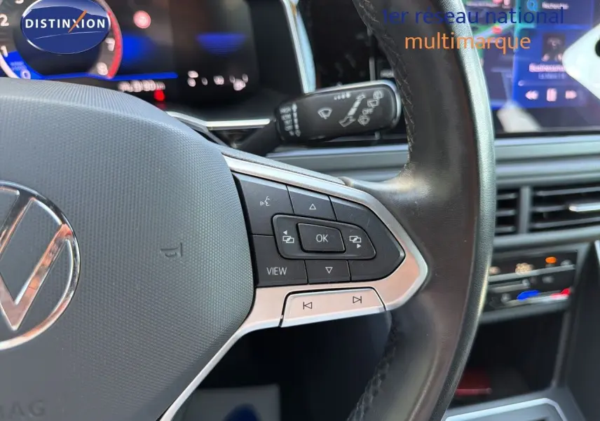 Gros plan sur le volant multifonction noir et argenté de la Volkswagen Polo 2023, avec tableau de bord numérique en arrière-plan.
