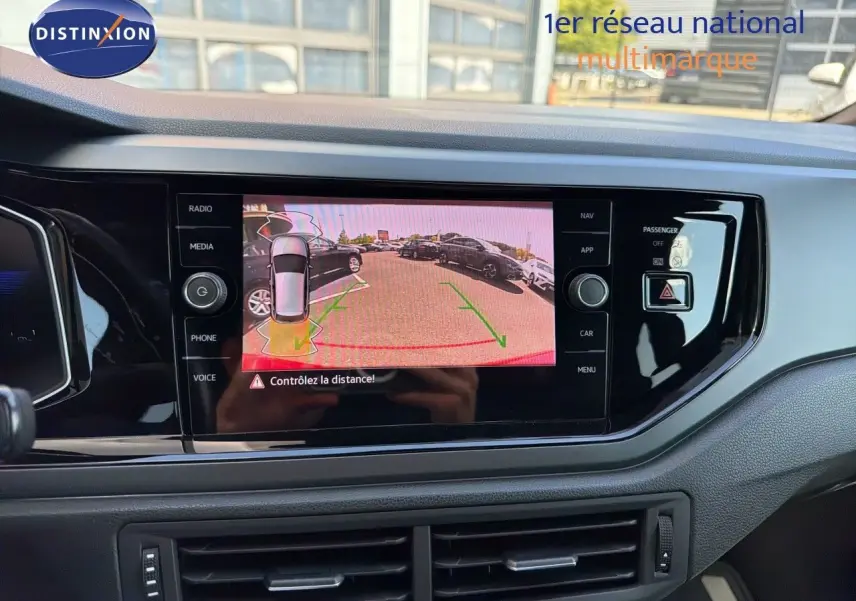 Vue intérieure du tableau de bord de la Volkswagen Polo rouge Roi 2023 avec écran de caméra de recul allumé.