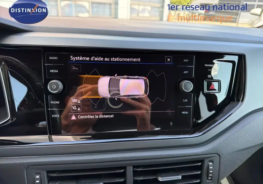 Vue rapprochée de l'écran tactile intérieur affichant le système d'aide au stationnement d'une Volkswagen Polo 2023.