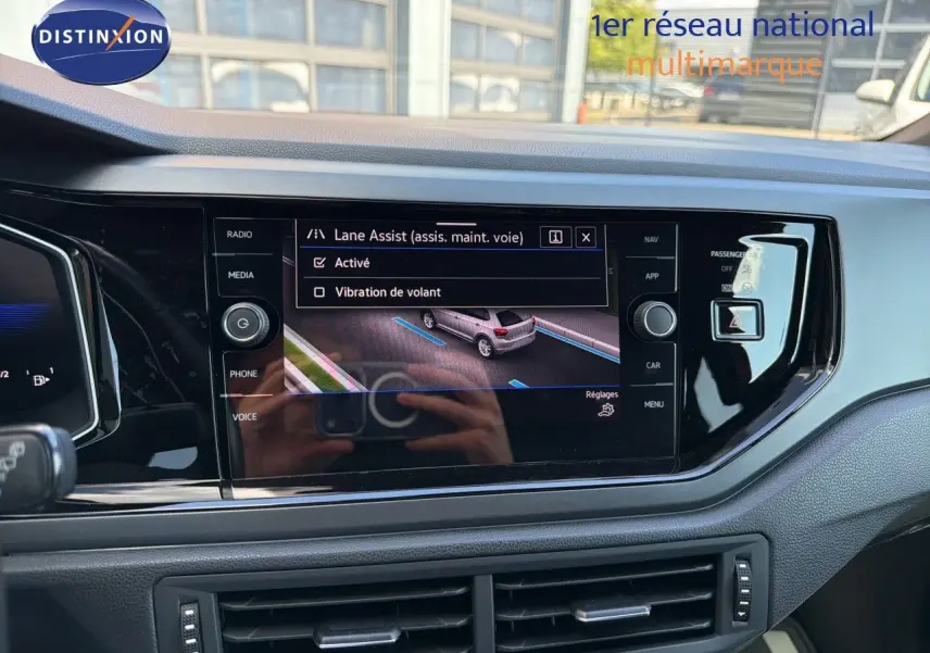Vue intérieure centrée sur l'écran tactile du tableau de bord de la Volkswagen Polo 2023 avec affichage du Lane Assist.