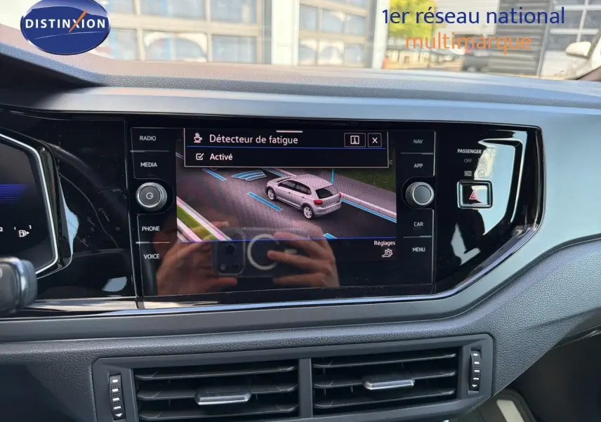 Vue rapprochée de l’écran central tactile du tableau de bord d’une Volkswagen Polo rouge Roi 2023 avec interface active.
