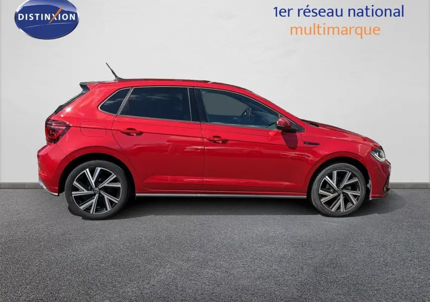 Profil droit d'une Volkswagen Polo rouge roi 2023 finition R-Line avec jantes alliage bicolores.