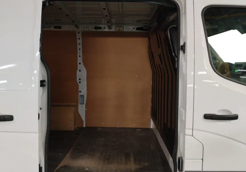 Vue intérieure de la zone de chargement du Renault Master blanc 2023, avec parois en bois et sol noir antidérapant.