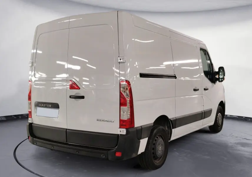 Vue 3/4 arrière droite d’un Renault Master blanc 2023, fourgon utilitaire avec bande noire latérale et feux arrière verticaux.