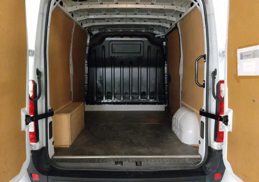 Vue arrière du Renault Master blanc L1H1 2023, montrant l’espace de chargement vide avec parois en bois et sol noir.