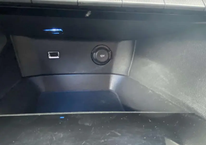 Prise USB et prise 12V en gros plan dans le compartiment de la Peugeot 3008 blanche, version Allure 2017.