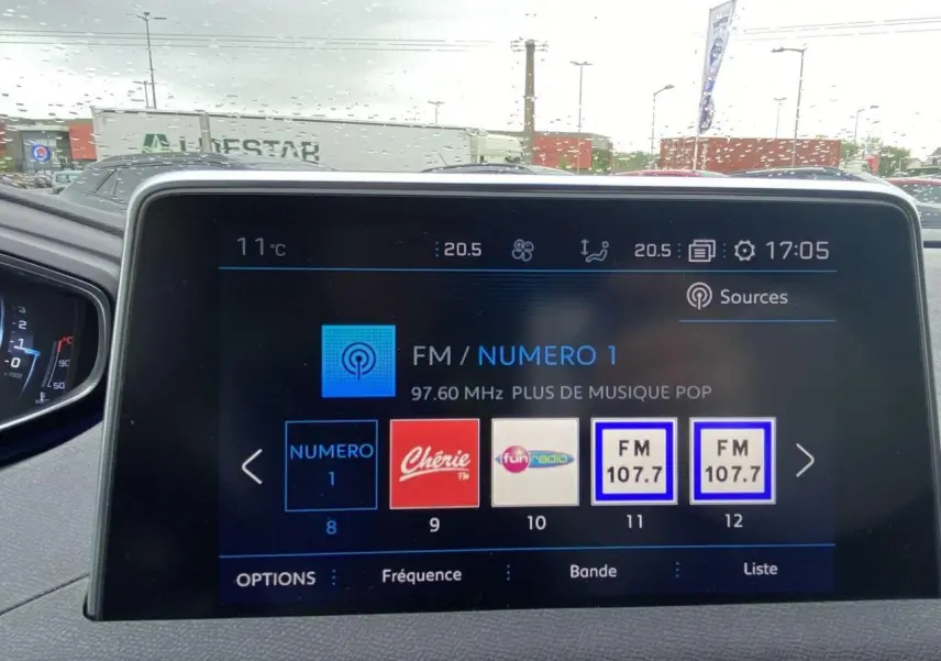 Vue intérieure du tableau de bord du Peugeot 3008 blanc 2017, écran tactile multimédia affichant les stations radio FM.