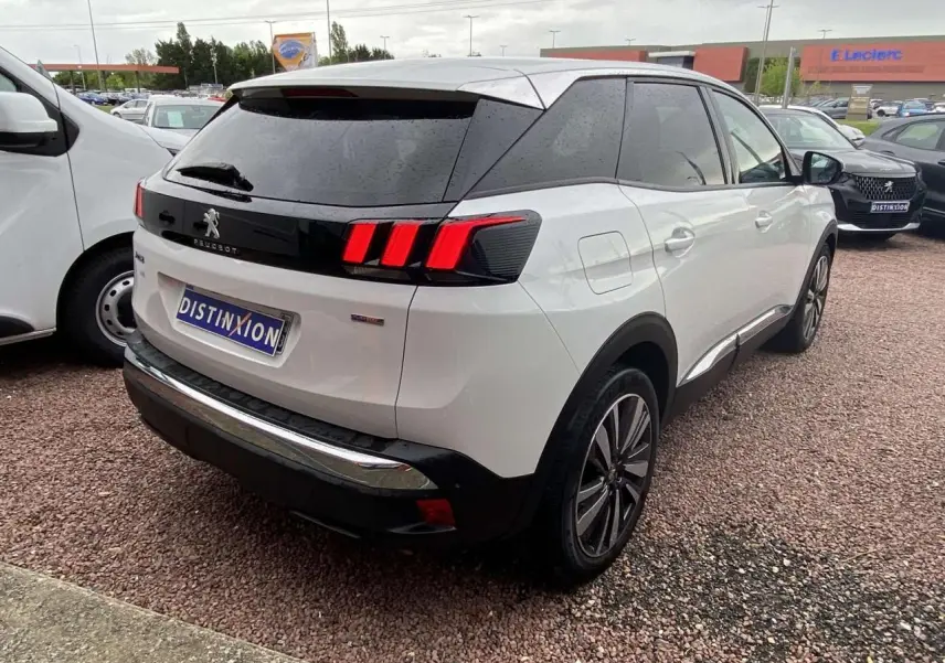 Vue 3/4 arrière droite d'un Peugeot 3008 blanc nacré avec vitres surteintées et jantes alliage 19 pouces Washington.