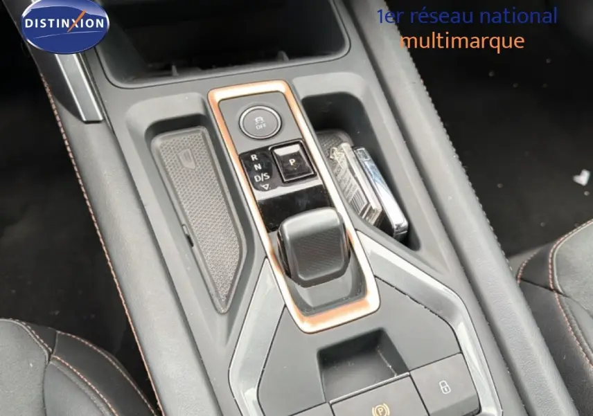 Gros plan sur la console centrale avec levier de vitesses automatique et finitions cuivrées du CUPRA Formentor blanc neige 2025.