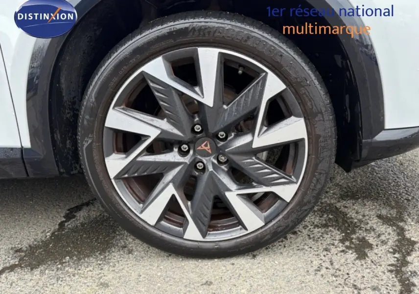 Gros plan sur la roue avant gauche de la CUPRA Formentor blanc neige métal avec jante alliage au design géométrique.