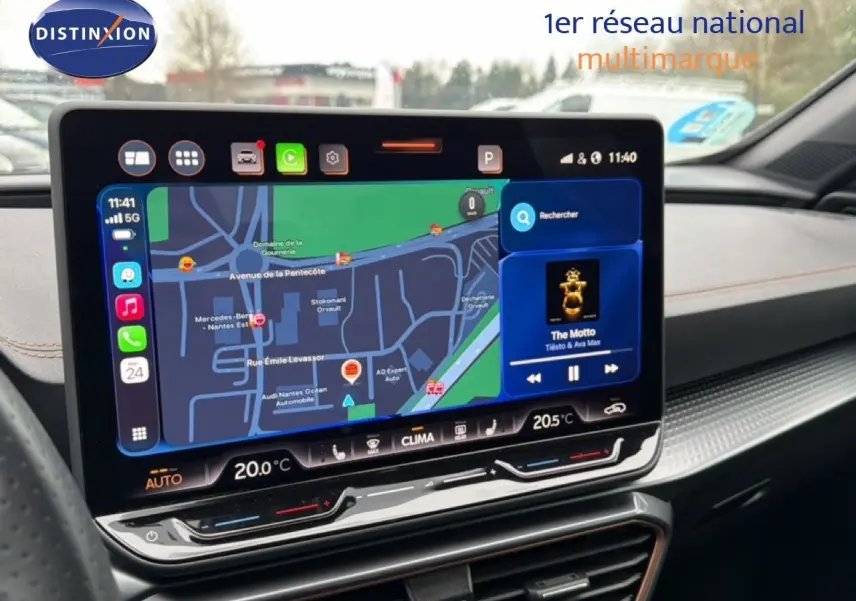 Vue intérieure centrée sur l'écran tactile du tableau de bord de la CUPRA Formentor blanc neige, affichant la navigation et la musique.