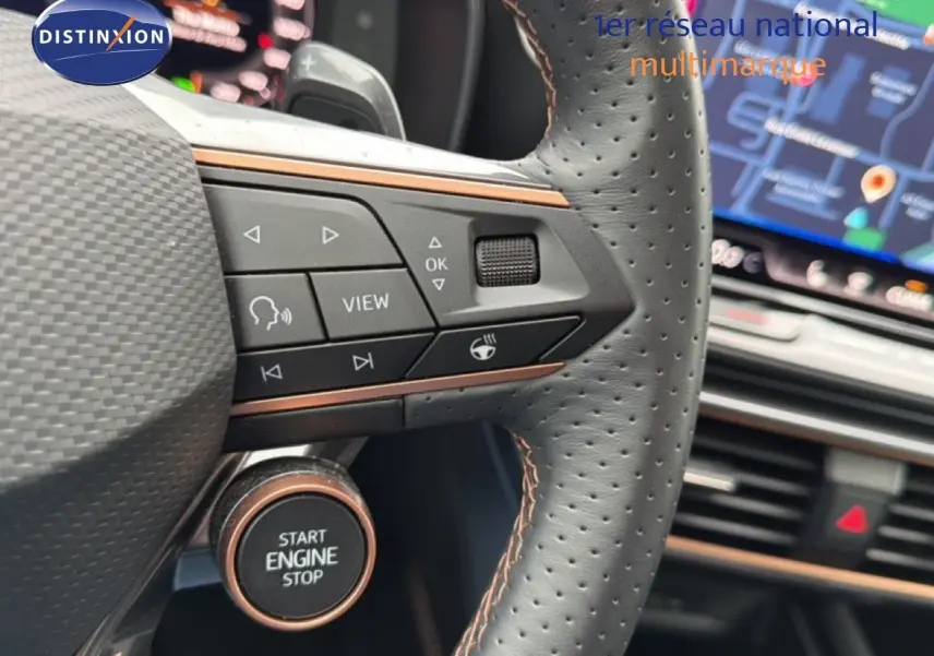 Gros plan sur le volant perforé noir avec commandes intégrées et bouton start/stop cuivré du CUPRA Formentor blanc neige 2025.