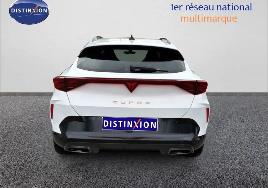 Vue arrière d'une CUPRA Formentor blanc neige métal 2025 avec feux arrière reliés et double sortie d'échappement intégrée.