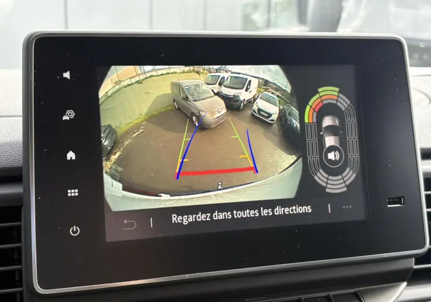 Vue caméra de recul montrant plusieurs véhicules blancs, dont un Renault Trafic Fourgon blanc en 3/4 arrière.