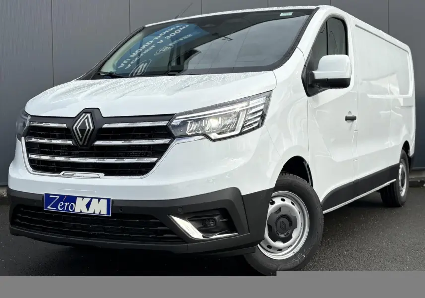 Vue 3/4 avant droite du Renault Trafic Fourgon blanc Glacier avec calandre noire et phares LED allumés.