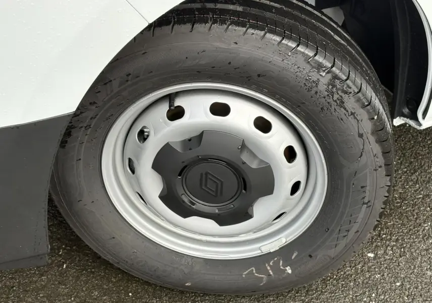 Gros plan sur la roue avant gauche du Renault Trafic Fourgon blanc glacier, avec jante acier et logo Renault central.