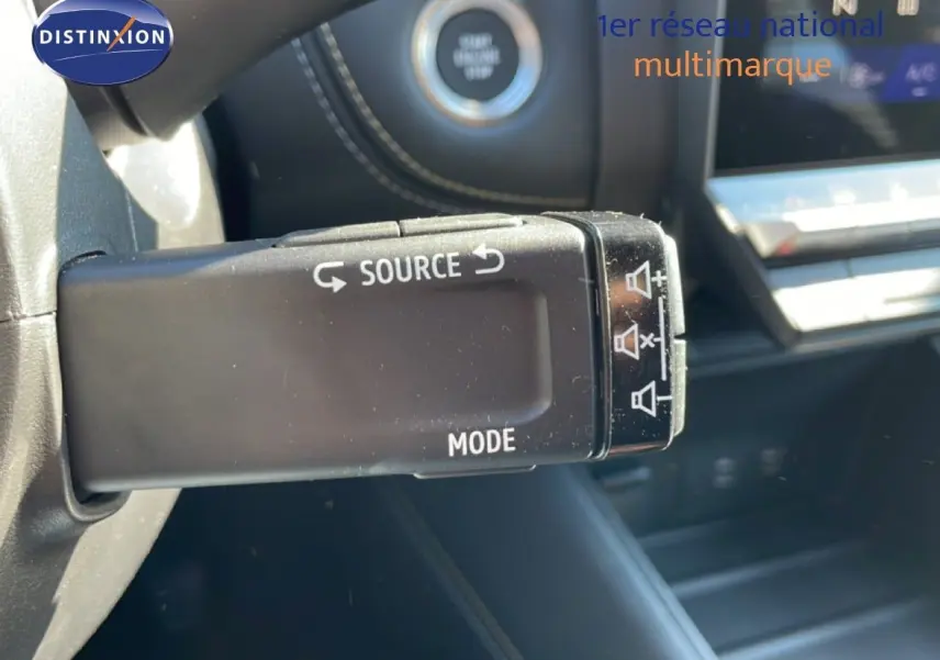 Gros plan sur la commande au volant de la Renault Symbioz 2025, avec bouton source et mode, intérieur noir.