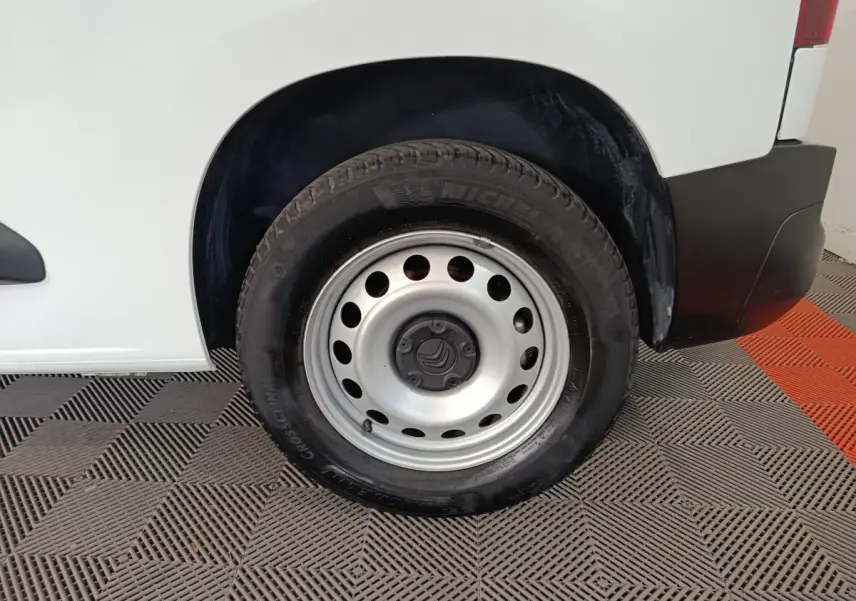 Gros plan sur la roue arrière droite d’un Citroën Berlingo blanc 2021 avec jante acier et pneu Michelin.