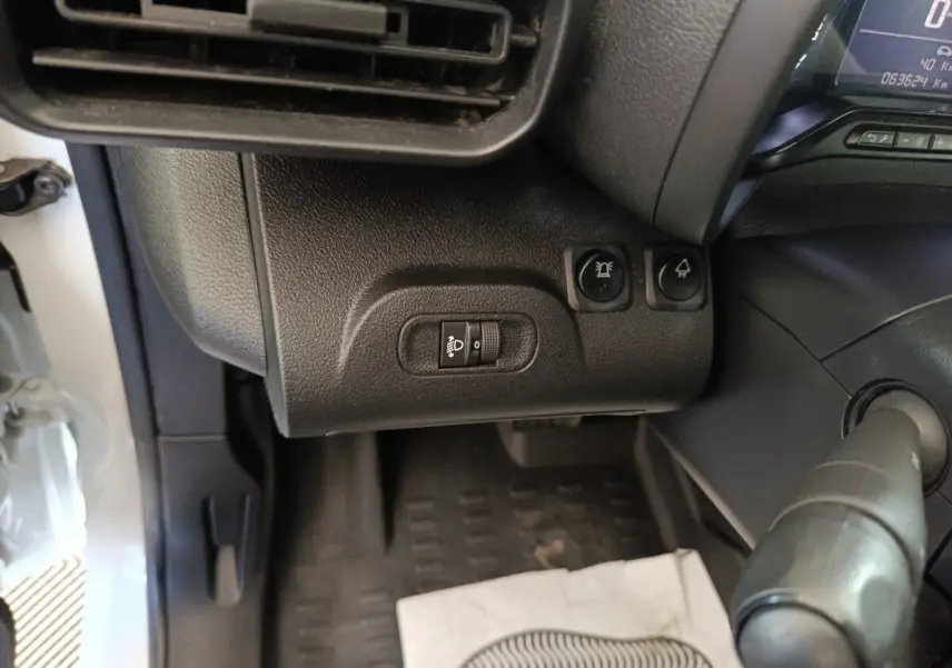 Vue intérieure côté gauche du tableau de bord du Citroën Berlingo blanc 2021, avec commandes d’éclairage et ventilation.