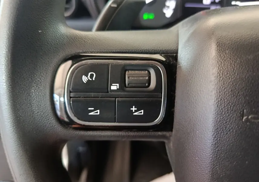 Gros plan sur les commandes au volant côté gauche du Citroën Berlingo blanc 2021, avec boutons de volume et appel.