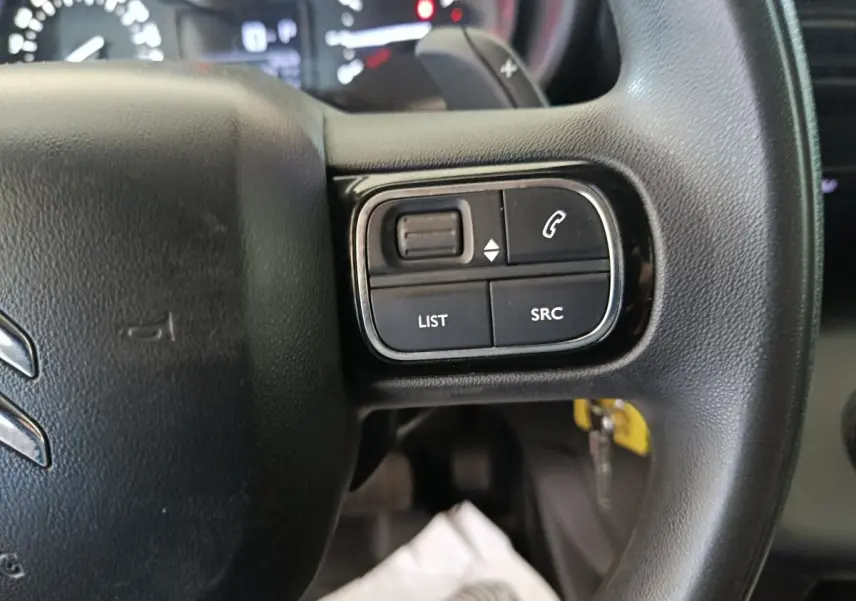 Gros plan sur les commandes au volant côté droit du Citroën Berlingo blanc 2021, avec boutons de gestion audio et appel.
