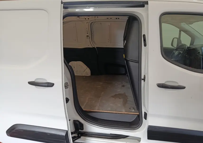 Vue latérale gauche d’un Citroën Berlingo blanc 2021 avec porte coulissante ouverte dévoilant l’espace de chargement vide.
