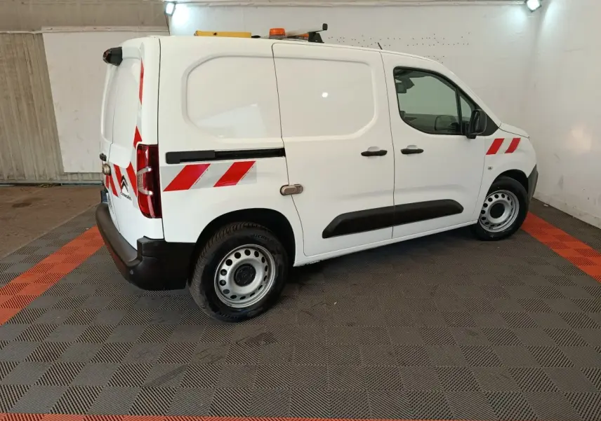 Vue de profil côté droit d’un Citroën Berlingo blanc 2021 avec bandes réfléchissantes rouges et feux arrière visibles.