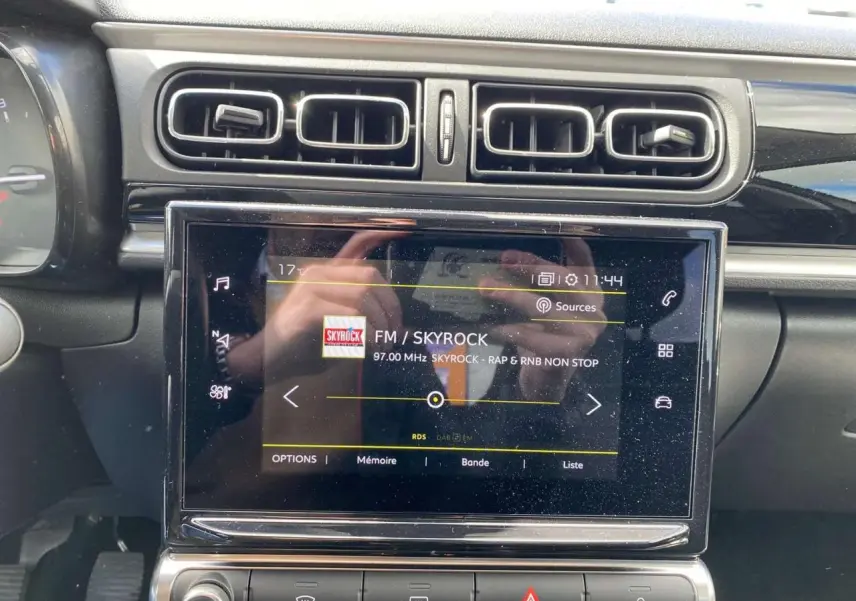 Tablette tactile centrale affichant la radio Skyrock, entourée des aérateurs et commandes du tableau de bord d'une Citroën C3 2021.