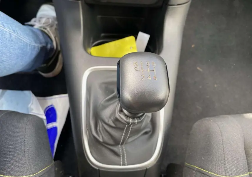 Le levier de vitesse manuel noir de la Citroën C3 2021 vu de dessus entre les sièges avant.