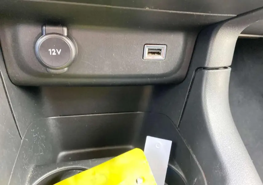 Prise 12V et port USB dans le rangement central avant d'une Citroën C3 2021, intérieur noir.