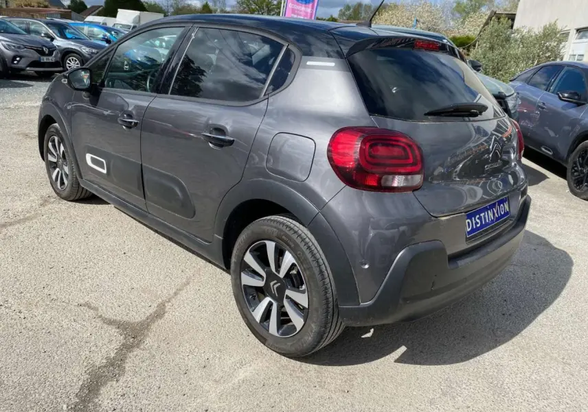 Vue 3/4 arrière droite d'une Citroën C3 gris platinium avec toit noir et jantes alliage diamantées.