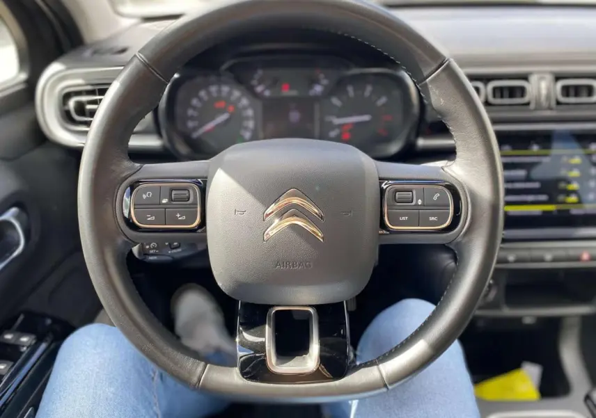 Vue centrée sur le volant noir de la Citroën C3 2021, avec tableau de bord et écran tactile en arrière-plan.
