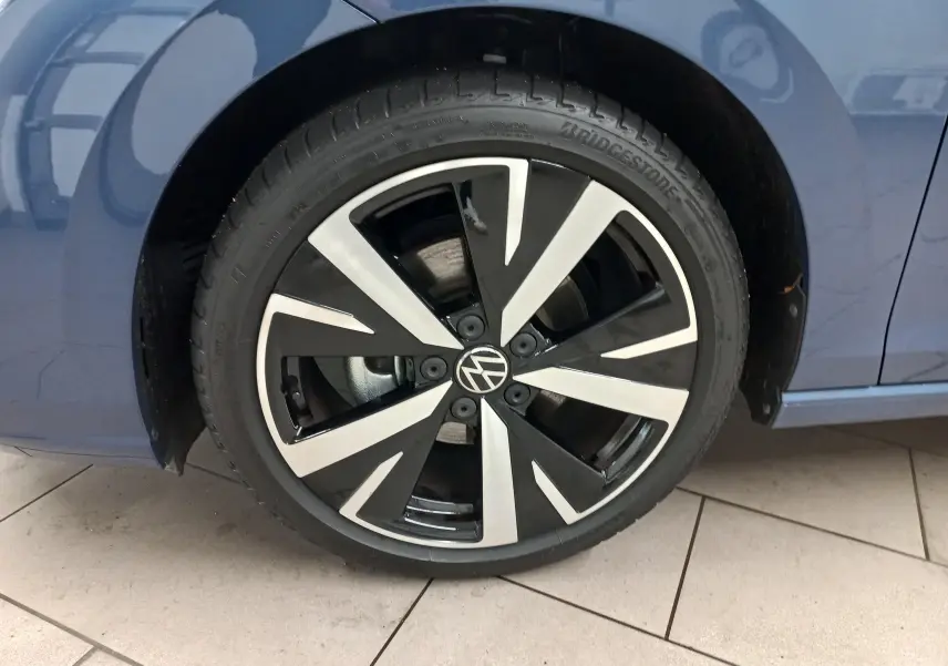 Gros plan sur la jante alliage 18'' Catania noire et argentée du côté avant droit d'une Volkswagen Golf Bleu Anemone.