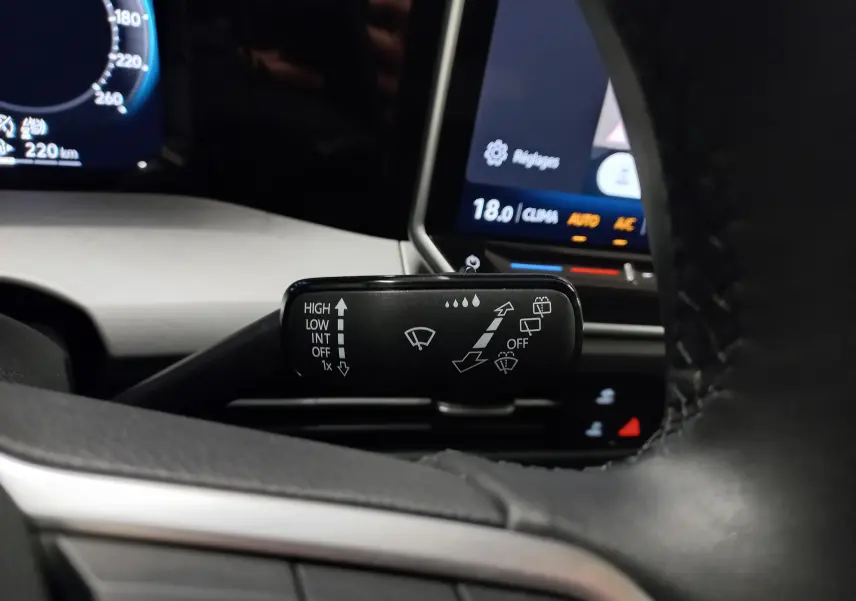 Gros plan sur la manette d’essuie-glace à gauche du volant d’une Volkswagen Golf Bleu Anemone, tableau de bord en arrière-plan.