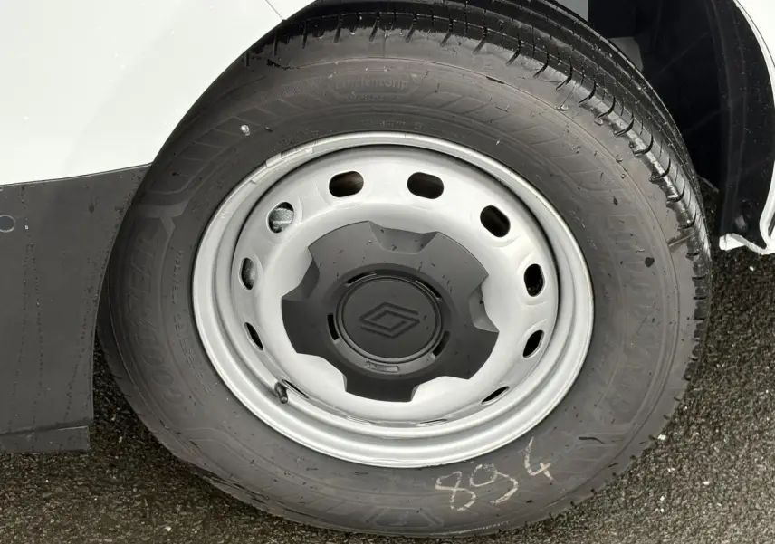 Gros plan sur la roue avant droite du Renault Trafic Fourgon blanc Glacier avec jante acier et logo Renault central.