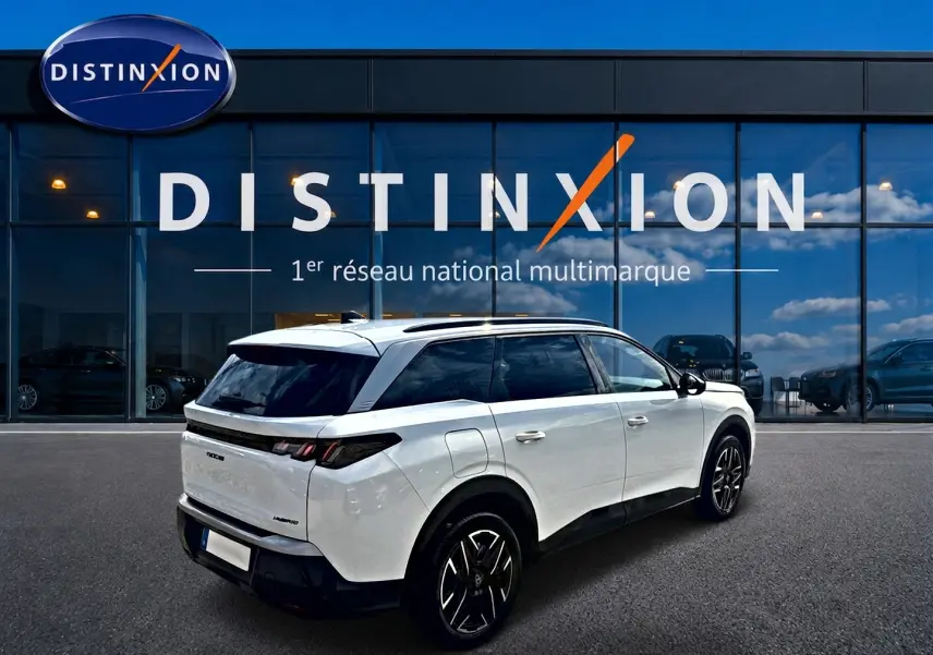 Peugeot 5008 Hybrid blanc vue 3/4 arrière droit, jantes alu noires et vitres arrière surteintées.