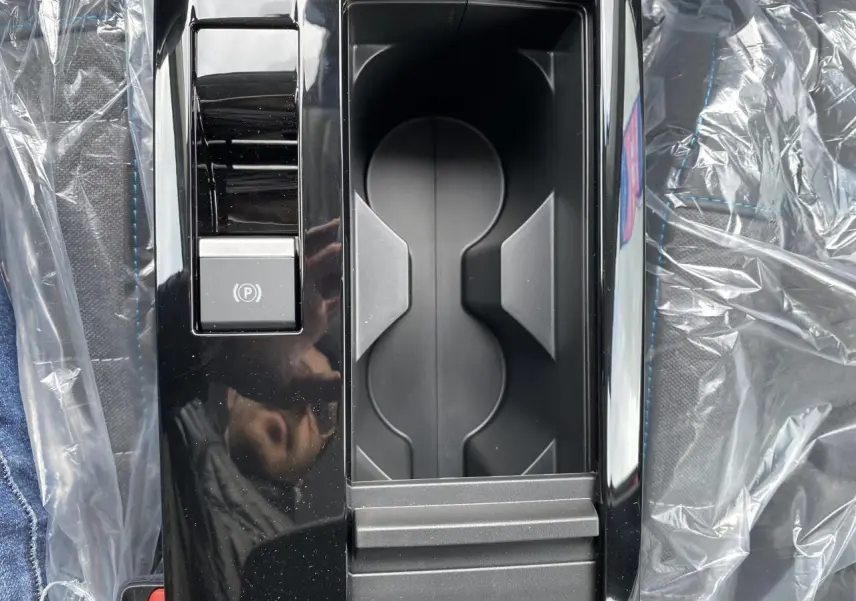 Gros plan sur la console centrale noire brillante avec frein de stationnement électrique dans une Citroën C4 Rouge Elixir 2023