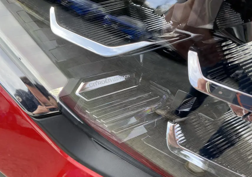 Gros plan sur le phare avant droit rouge Elixir de la Citroën C4 2023 avec signature lumineuse LED distinctive.