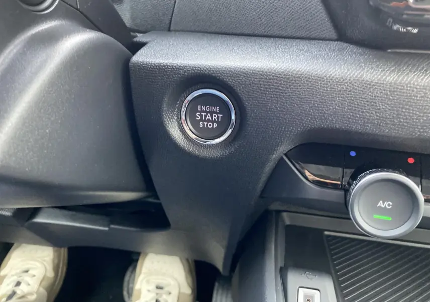 Bouton start/stop moteur et commande de climatisation sur tableau de bord d'une Citroën C4 2023 vue côté conducteur.