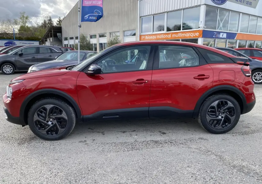 Profil côté gauche d'un Citroën C4 2023 en Rouge Elixir avec jantes alliage 18 pouces et toit noir contrasté.