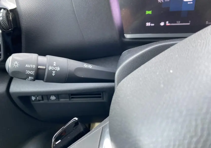 Gros plan sur la manette des feux et clignotants côté gauche du tableau de bord d'une Citroën C4 Rouge Elixir 2023.