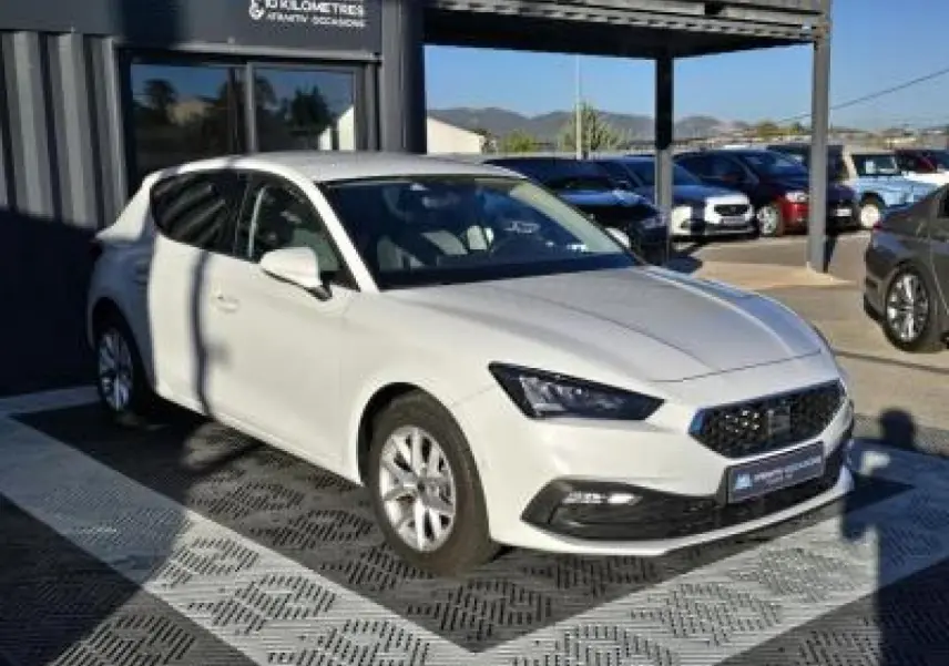 SEAT Leon IV blanc vu en 3/4 avant gauche, avec calandre noire et jantes alliage 16 pouces.
