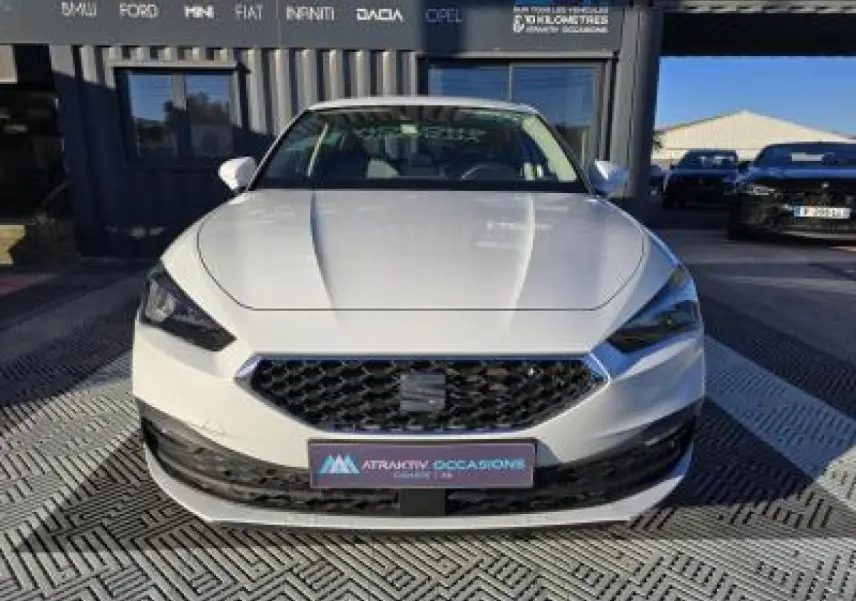 Vue frontale d'une SEAT LEON blanche 2024 avec calandre noire et phares LED anguleux.