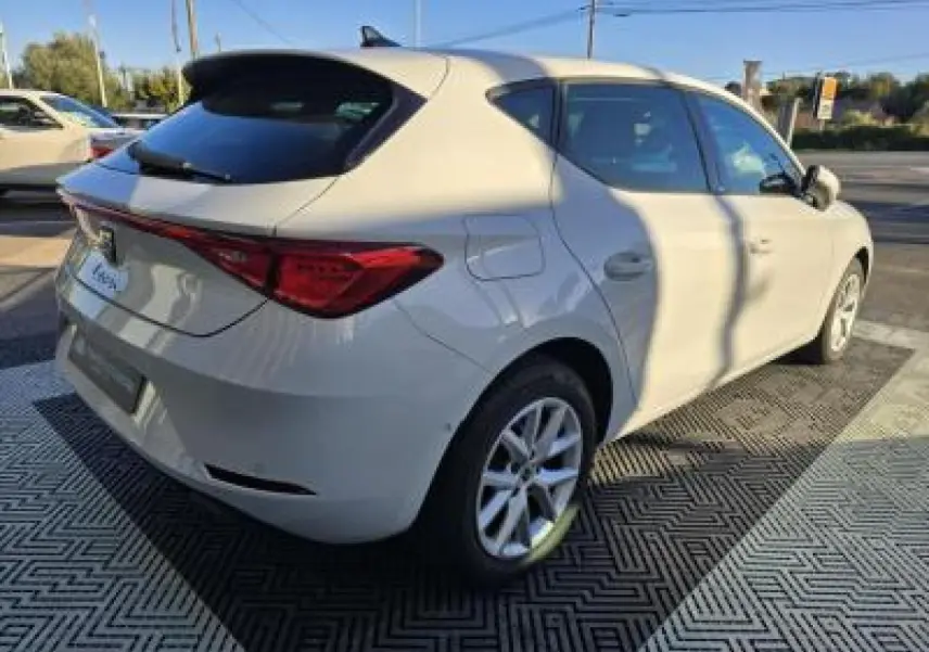 SEAT LEON blanc vue 3/4 arrière droit, jantes alliage 16 pouces, feux arrière LED et toit noir contrasté.