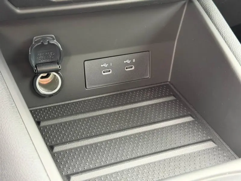 Gros plan intérieur sur la console centrale du Renault Captur 2026, montrant prises USB-C et prise 12V dans un espace noir mat.