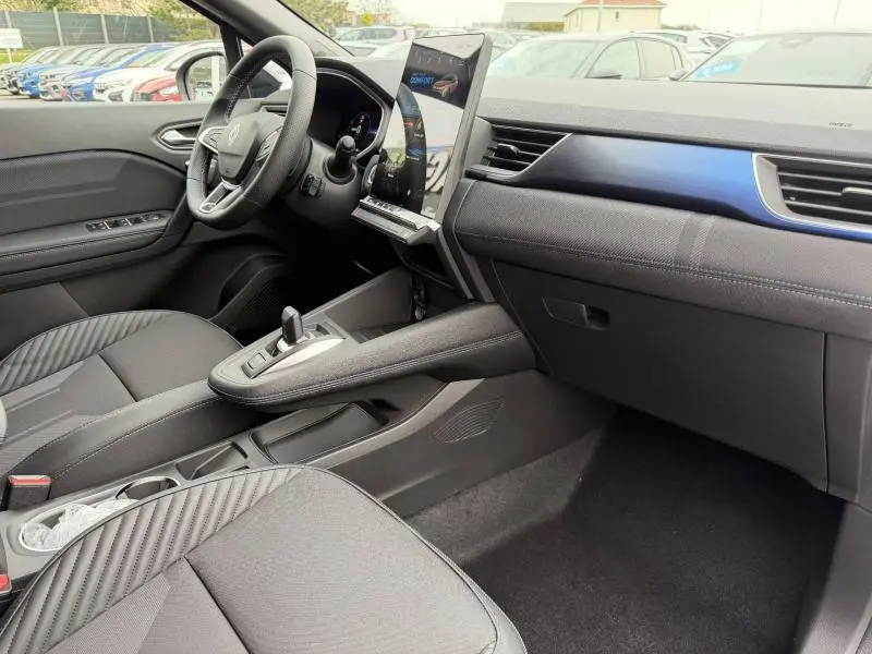 Vue intérieure côté conducteur du Renault Captur 2026 gris Rafale/Noir Étoilé, avec écran tactile vertical et volant multifonction.