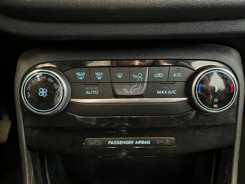 Gros plan sur les commandes de climatisation noire du Ford Puma 2022 avec réglages ventilateur et température.