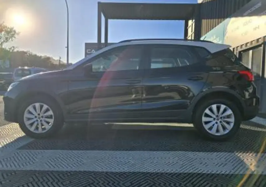 SEAT Arona noir minuit avec toit contrasté, vue de profil côté gauche en extérieur au soleil couchant.