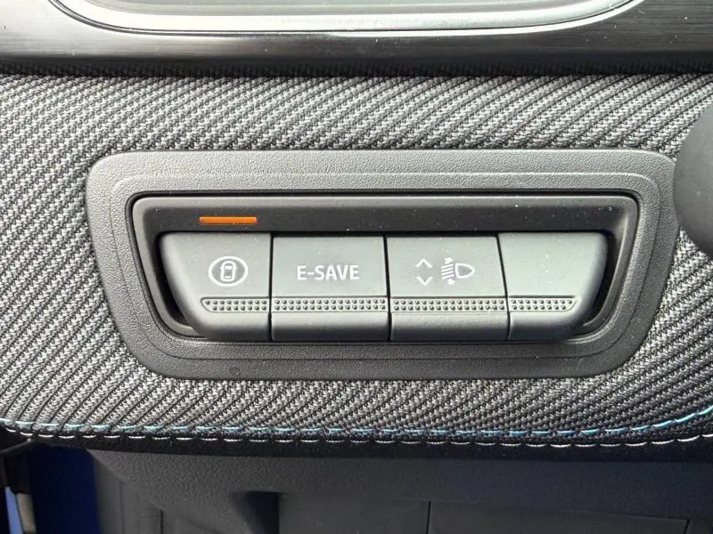 Gros plan sur les boutons de commande E-SAVE et réglage des phares du tableau de bord du Renault Captur Bleu Iron/Noir Etoilé.