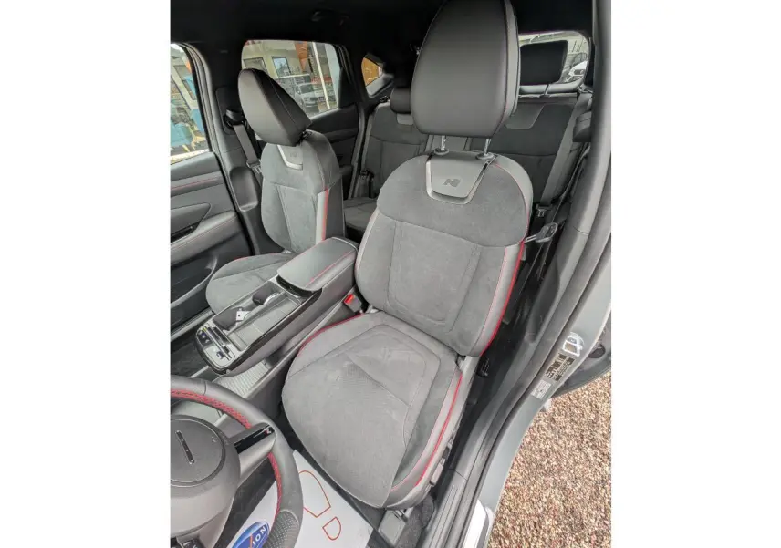 Vue intérieure côté conducteur du Hyundai Tucson gris, sièges N Line en cuir/alcantara avec surpiqûres rouges.